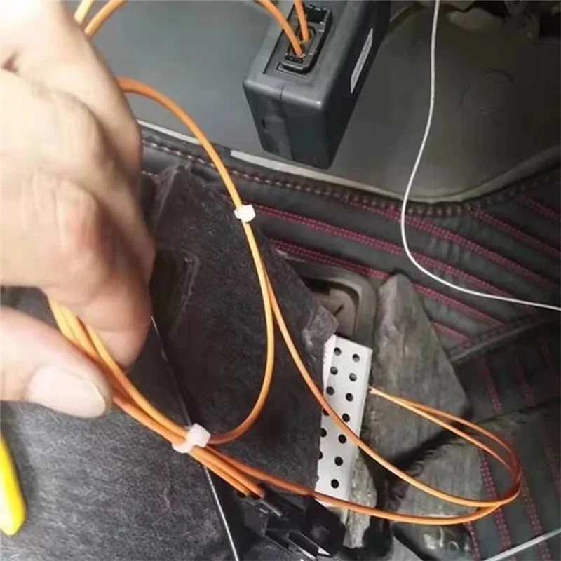 Orange fiber optic cables secured with white ties on the back side of mmi 2g bluetooth music adapter adapter foraudi a6l