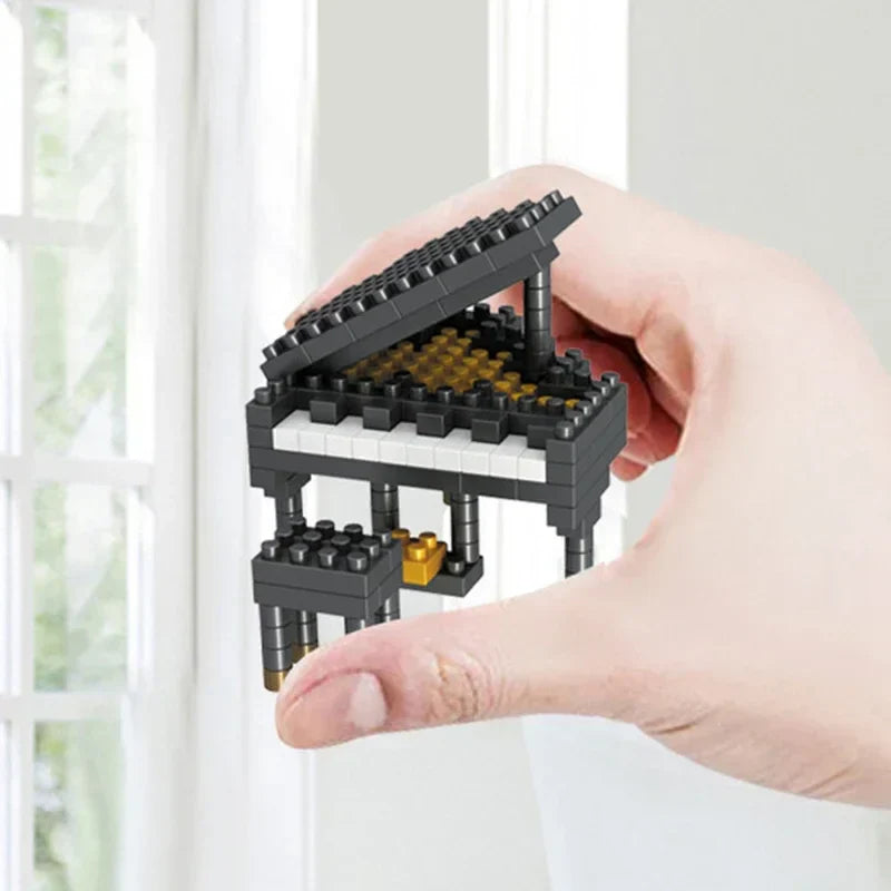 A miniature black and gold mini piano made from abs plastic bricks held in hand for musical instrument building and guitar diy assembly