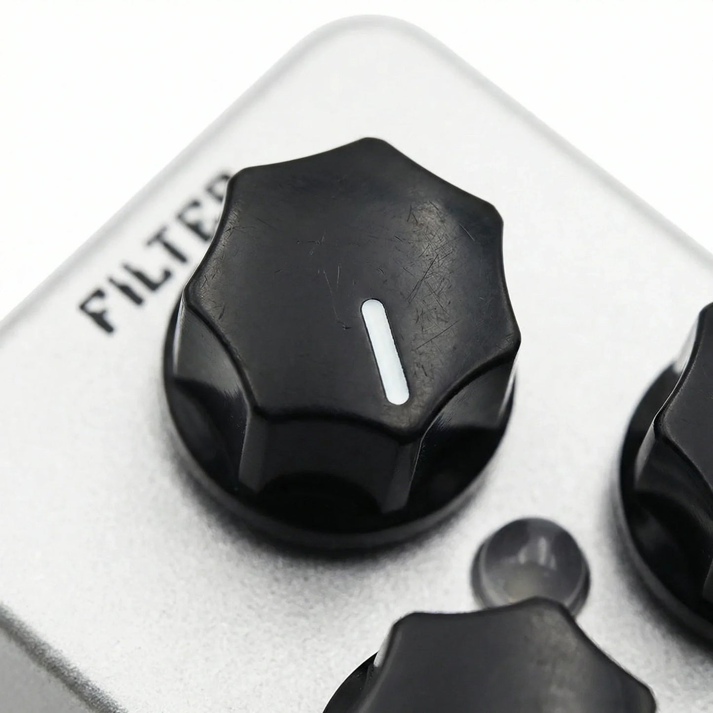 Black hexagonal knob with white stripe on silver panel of moskyaudio mini string clean drive overdrive guitar pedal