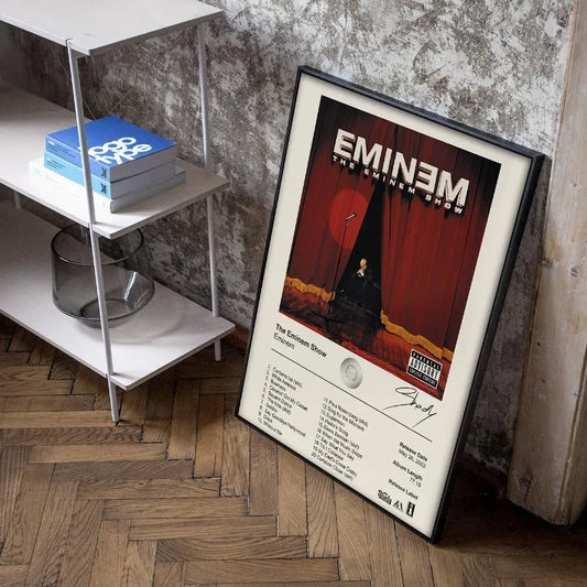 Black-framed poster of eminem’s album ’the eminem show’ featuring a red curtain backdrop and white text on the lower portion.
