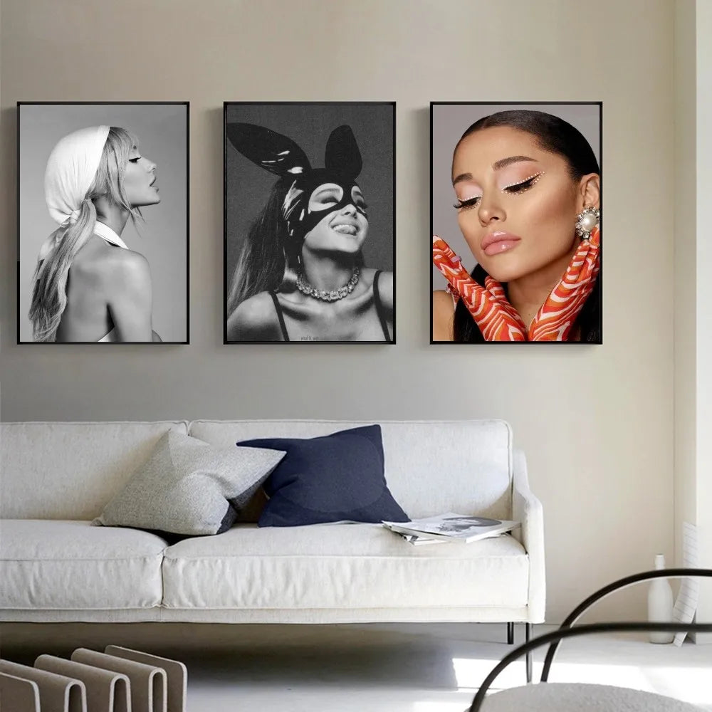 Three framed high quality ariana grande music art posters in black and white and color hang above a white sofa