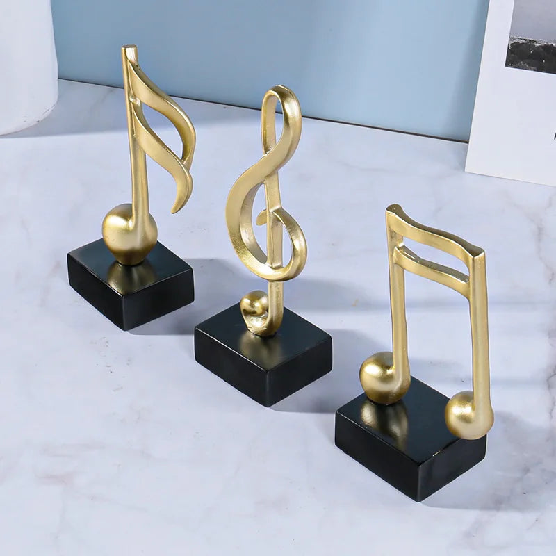 Three golden musical note statues made of music symbols resin crafts ornaments for piano desktop decoration
