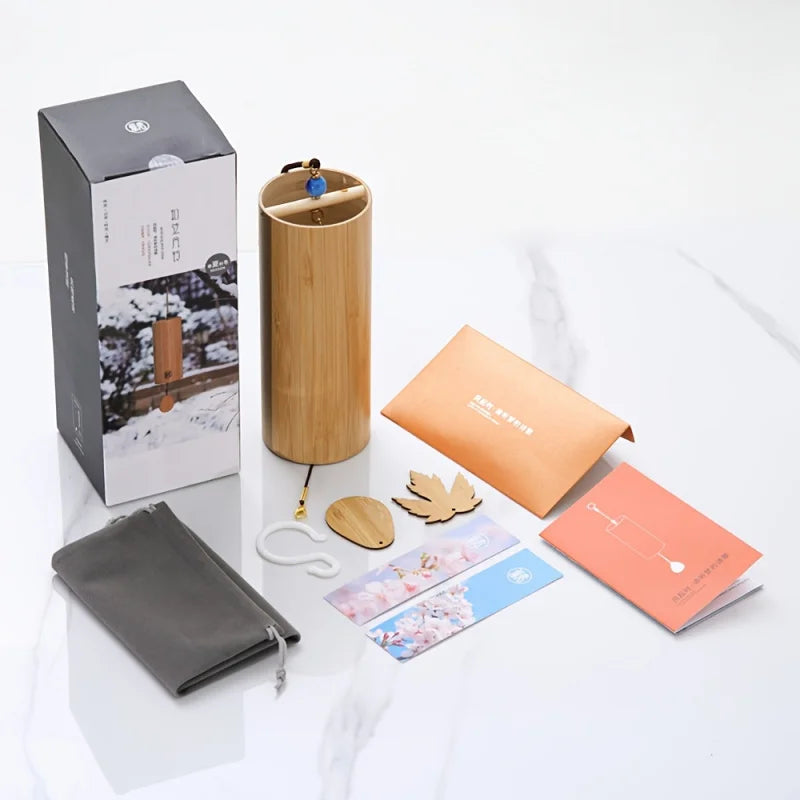 A cylindrical bamboo wind handbell with natural wood grain finish and a blue bead for refined meditation bells