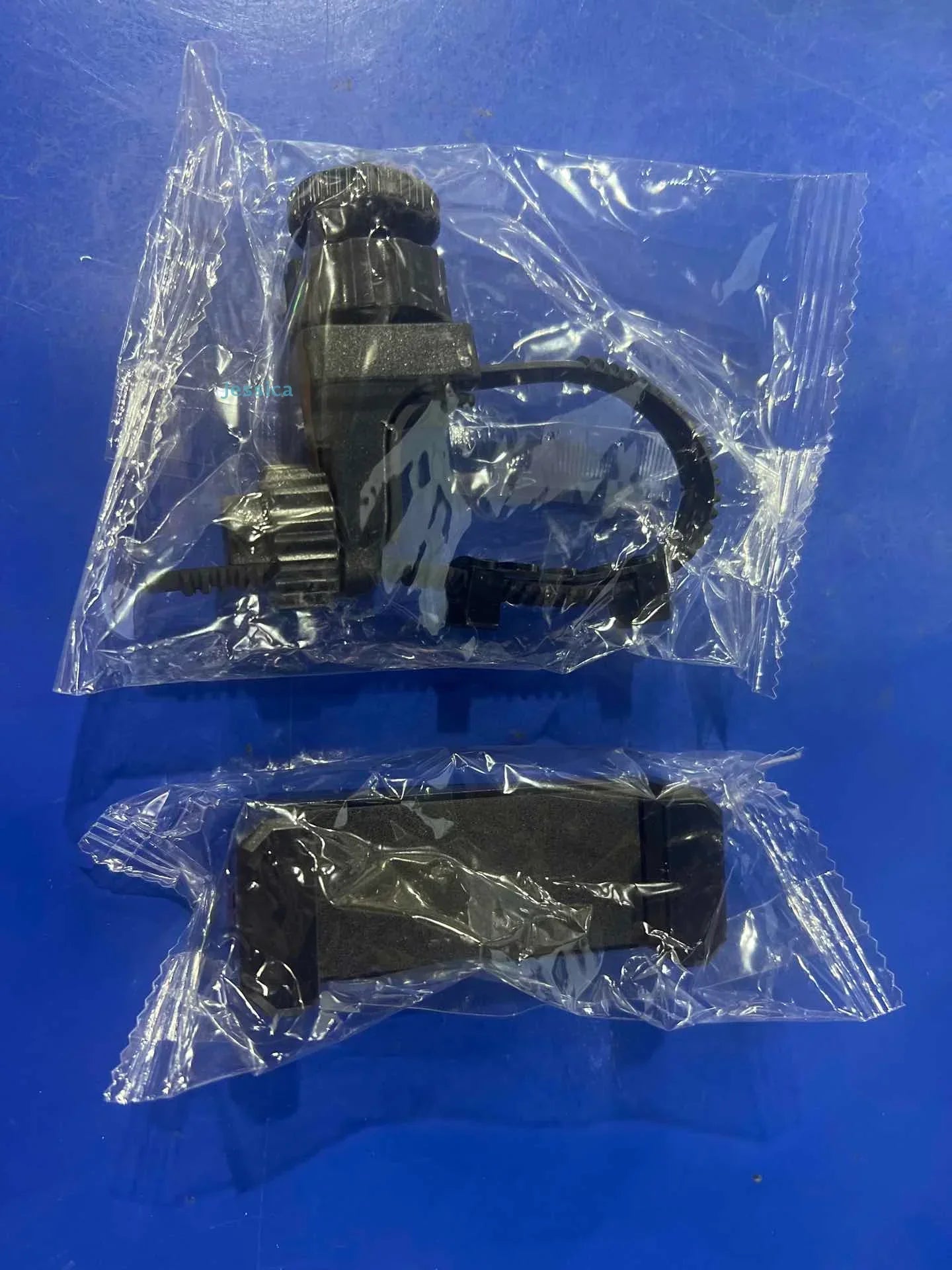 Black metal gear and bracket assembly in clear plastic packaging for multifunctional selfie recording lyre phone holder