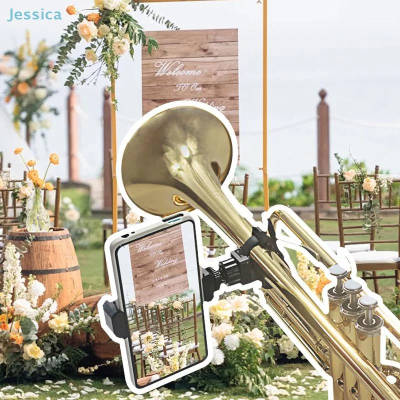 Gold-colored brass trumpet with black multifunctional lyre phone holder clip displaying wedding venue on smartphone