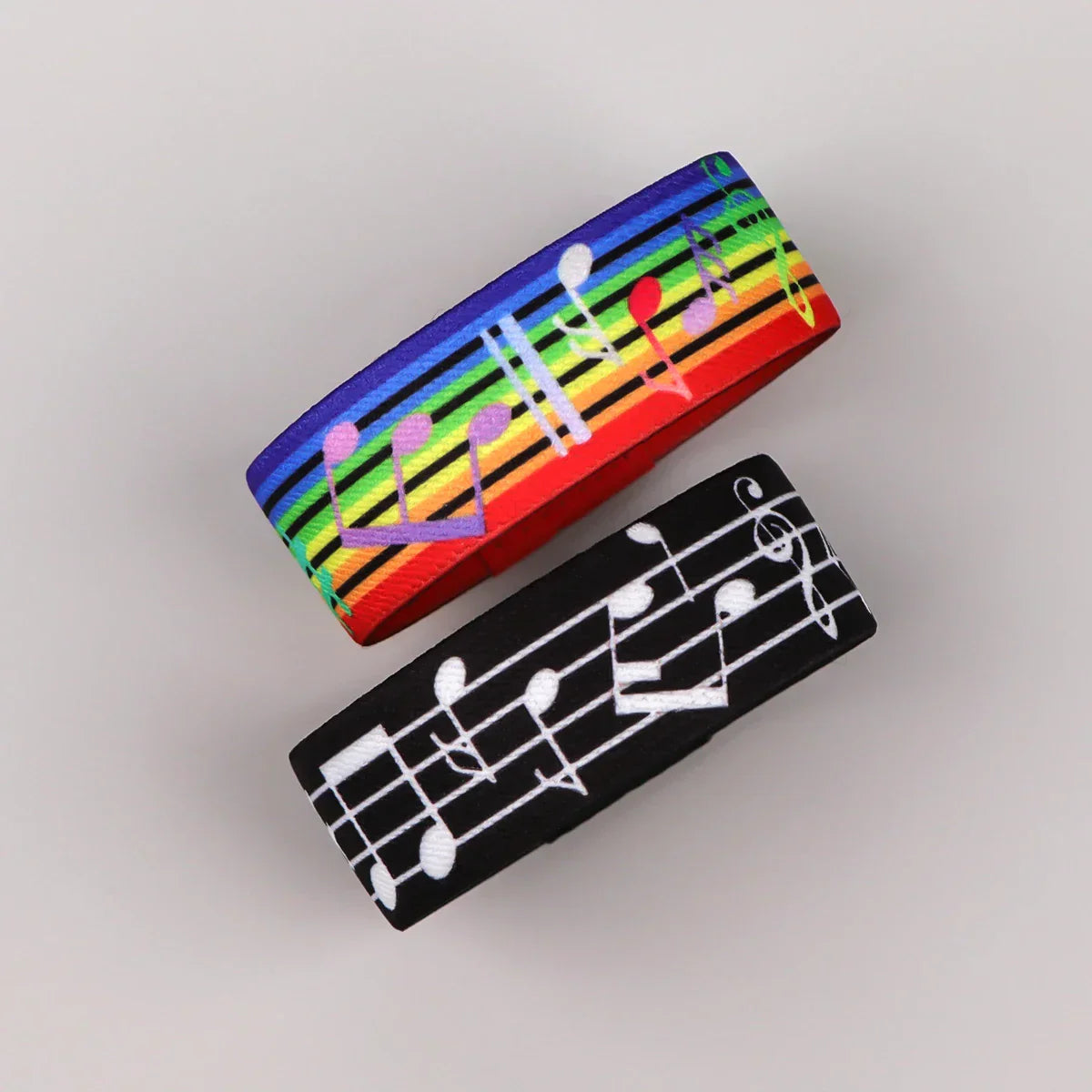 Musical notes bracelet set featuring a rainbow elastic bangle with colorful notes and a black men armband sport with sheet music