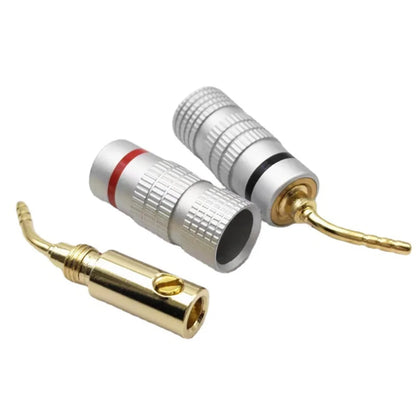 Silver and gold-colored 24k gold plated audio speaker connectors with textured bodies and red black bands for musical sound