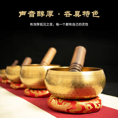 Golden nepali handmade buddha sound bowls with wooden mallets on red and gold cushions for sound bowl yoga and brass chime therapy