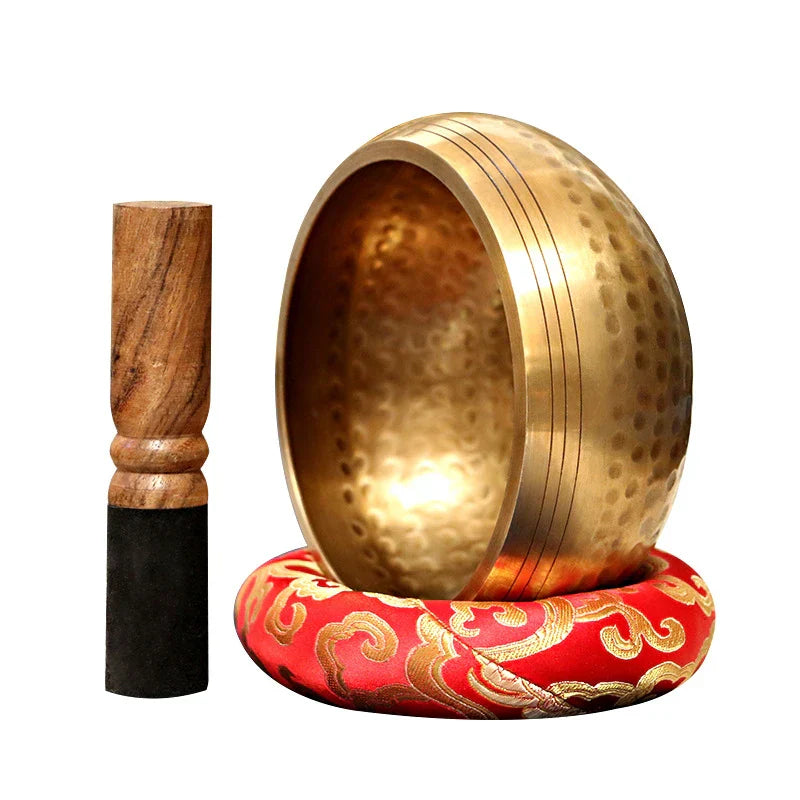 Golden handmade buddha sound bowl with hammered texture and concentric ridges on red cushion for sound bowl yoga