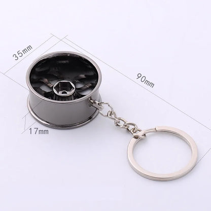 Silver metallic wheel rim keychain shaped like a miniature car wheel with black hub center for car key ring or hub key chain