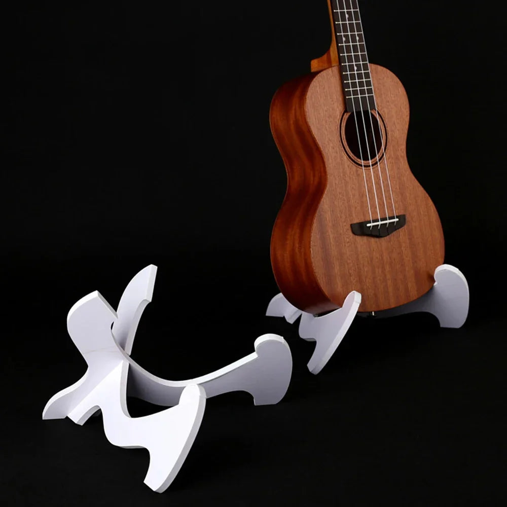 White sculptural foldable holder musical stand supporting a wooden ukulele for strings vertical ukulele display guitar stand