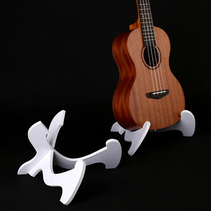 White sculptural foldable holder musical stand supporting a wooden ukulele for strings vertical ukulele display guitar stand