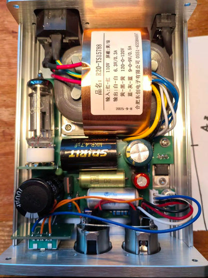 Copper-colored transformer with chinese label inside enclosure of new professional-grade vacuum tube microphone for recording studios