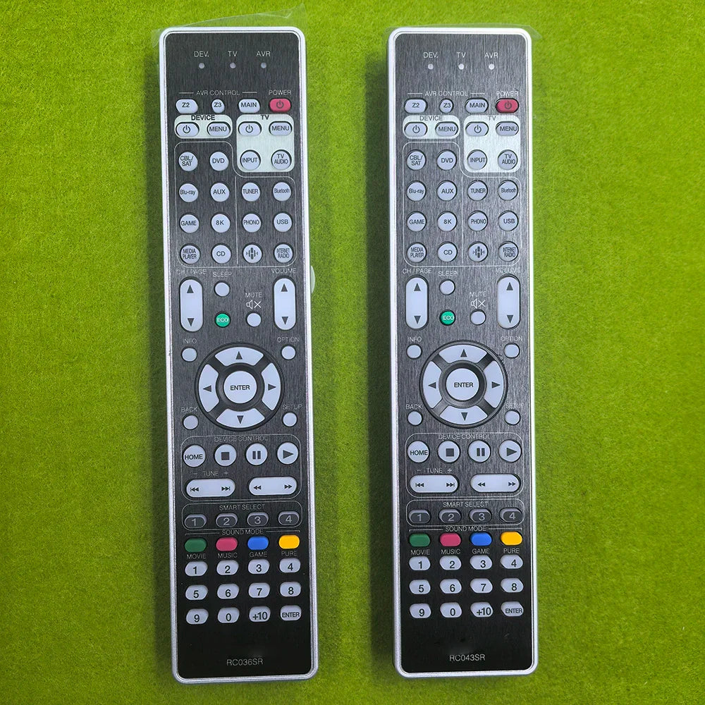 Two silver-toned remote controls with black accents and white buttons control rc036sr rc043sr marantz sr7012 sr7015 compatible