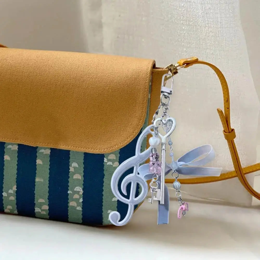 A delicate white resin music note keychain with heart design and pink beads for bags creative bag or phone pendant backpack