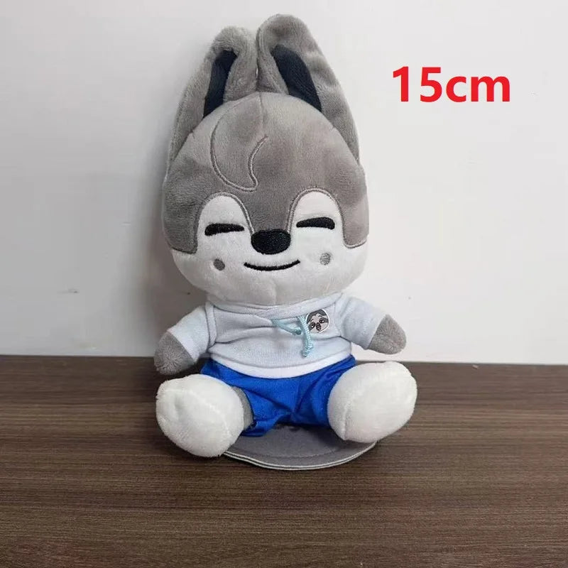 A 15cm gray and white wolf skzoo plush keychain wearing a light blue magic academy cloak and bright blue shorts toy fan gift