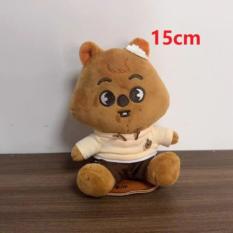A 15cm brown skzoo plush keychain bear wearing a cream magic academy cloak hoodie and dark pants toy fan gift