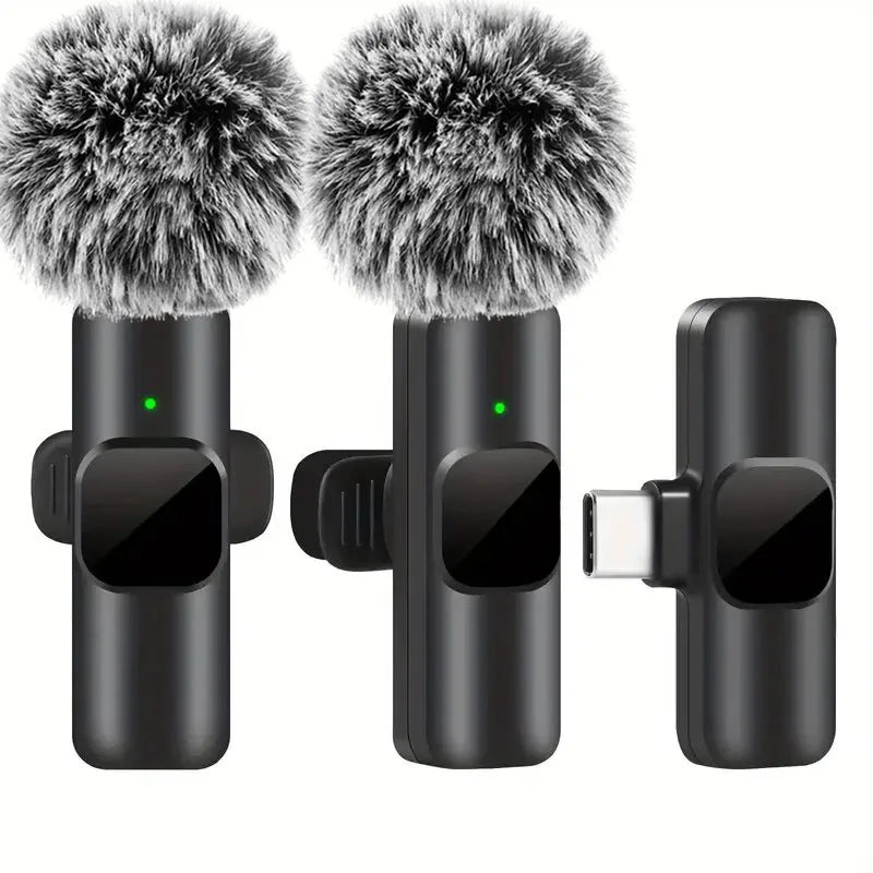 Black wireless lavalier microphone with fuzzy gray windshields and green indicator lights for portable audio video recording mini use