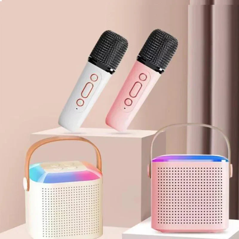 Two wireless microphone karaoke devices in white and pink with black mesh grille and control buttons for mp3 player karaoke