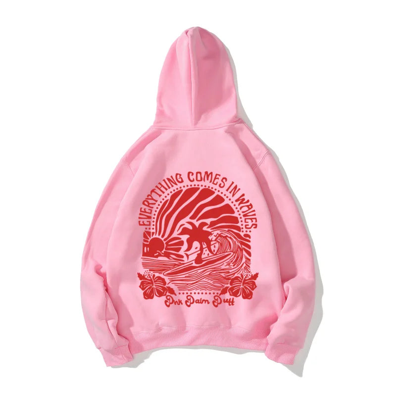 Pink hoodie with red graphic print of palm trees and waves and text everything comes in waves pink palm duff youth tropical flower