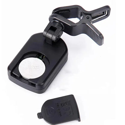 Black plastic clip-on lcd digital tuner with circular battery compartment and removable cover for string instruments