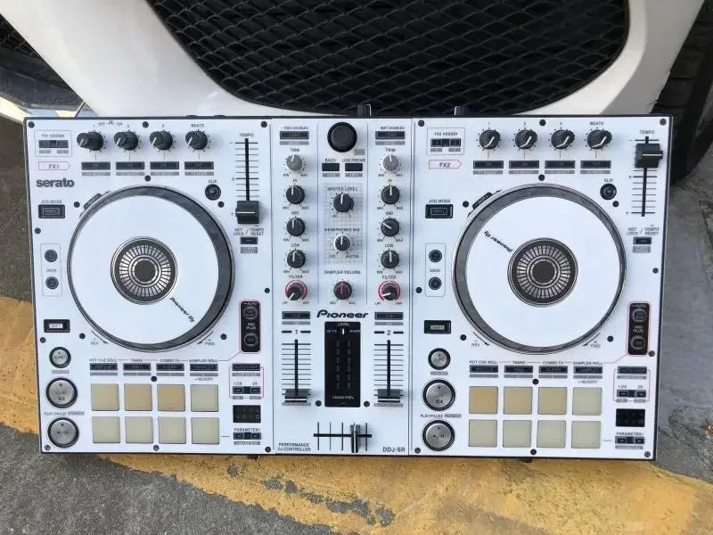 White pioneer ddj-sr dj controller with black silver accents and two jog wheels fully surrounded by protective stickers from beat music store