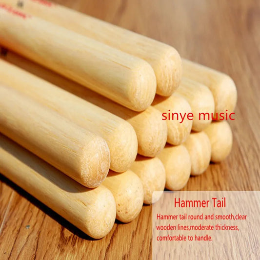 Light-colored wooden professional drum sticks 5a hickory with smooth rounded hammer tails and natural wood grain visible
