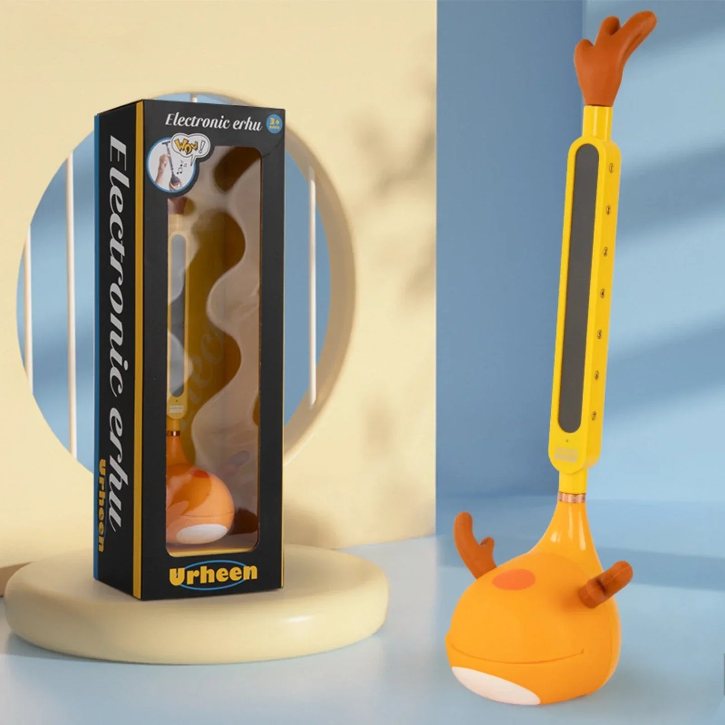 Yellow and orange otamatone electronic musical toy portable synthesizer with antler handle and plush body for educational fun