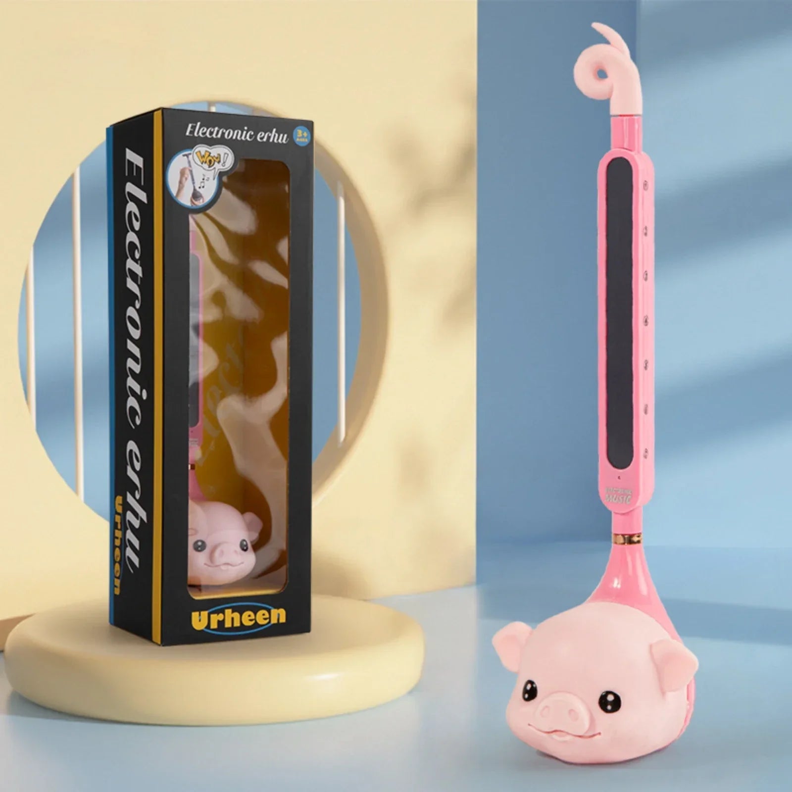 Pink pig-shaped otamatone electronic musical toy portable synthesizer with glossy plastic body and black control panel