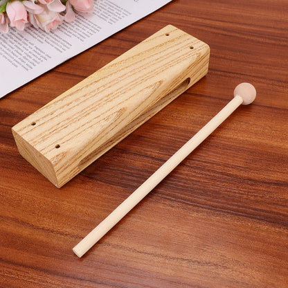 Light-colored wooden xylophone clapper made of madera dura una sola pieza with matching mallet for outdoor rhythm play