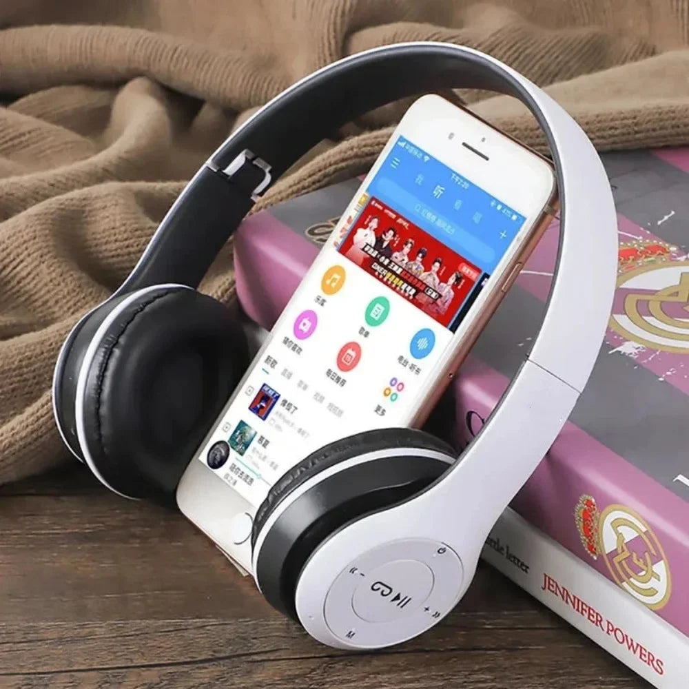 White and black p47 wireless bluetooth headphone with microphone foldable headsets and bass hifi sound resting on smartphone