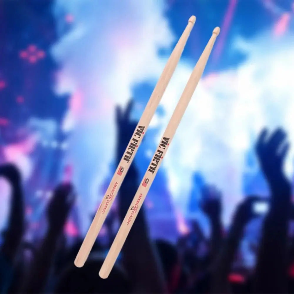 A pair of natural wood percussion musical instrument sticks with black and red vic firth american classic branding