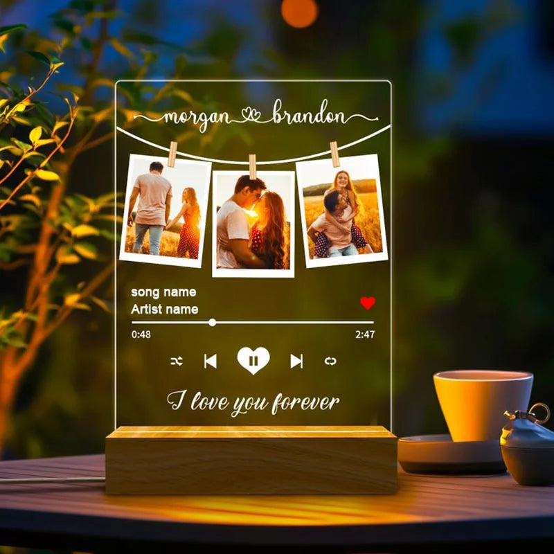 Clear acrylic personalised spotify music plaque with engraved names, three photos, playback controls, and wooden base