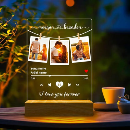 Clear acrylic personalised spotify music plaque with engraved names, three photos, playback controls, and wooden base