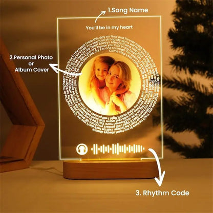 A warm translucent personalised acrylic spotify music plaque with circular photo and engraved lyric ring on wooden base
