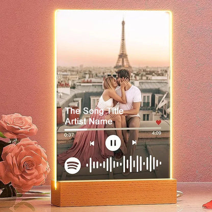 A glowing personalised acrylic spotify music plaque with a couple photo and wooden base led night light display