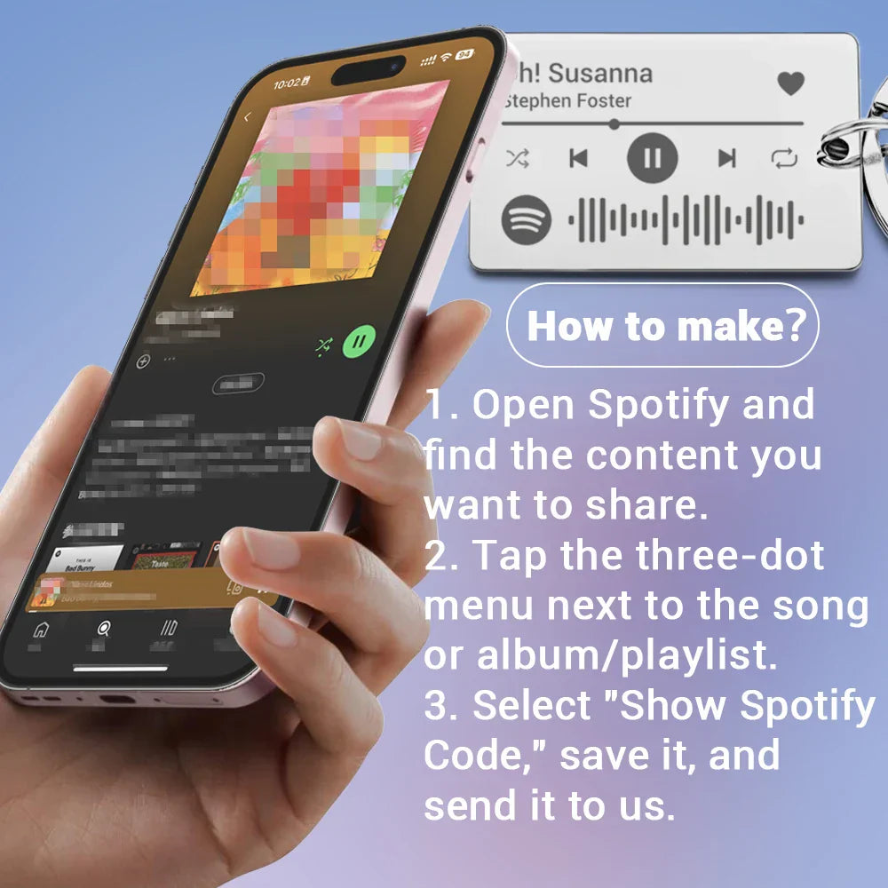 A hand holding a silver-framed iPhone displaying the Spotify app with a personalized custom Spotify code keychain