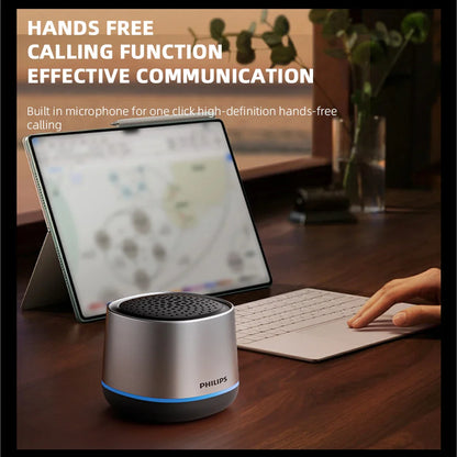 Silver cylindrical philips tas1009 bluetooth speaker with black perforated top and blue led ring for outdoor use