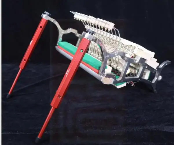 Red metal upright piano action repair stand with silver frame and green internal components for piano tools use