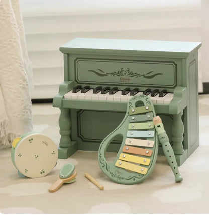 Pastel green wooden toy piano with ornate detailing and black and white keys for boys to play mechanical music