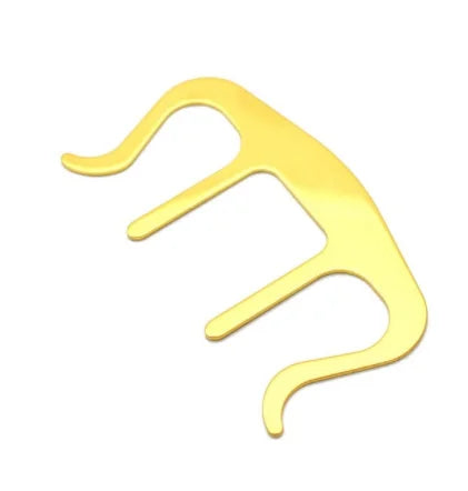 Gold-colored metal hair comb with three curved prongs used as holder clip music for pianos stands song and speech draft cooking