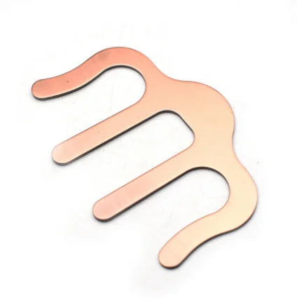 Copper-colored metal hair comb with three curved prongs used as a holder clip music for pianos stands song and speech draft cooking