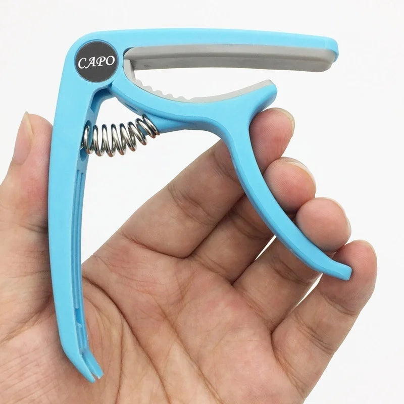 Light blue plastic guitar capo with silver spring and black capo logo for classic electric guitarra tuning clamp musical use