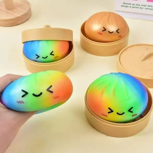 Rainbow-colored squishy stress ball with a cute smiling face featuring smiley face simulation and buns kneading music