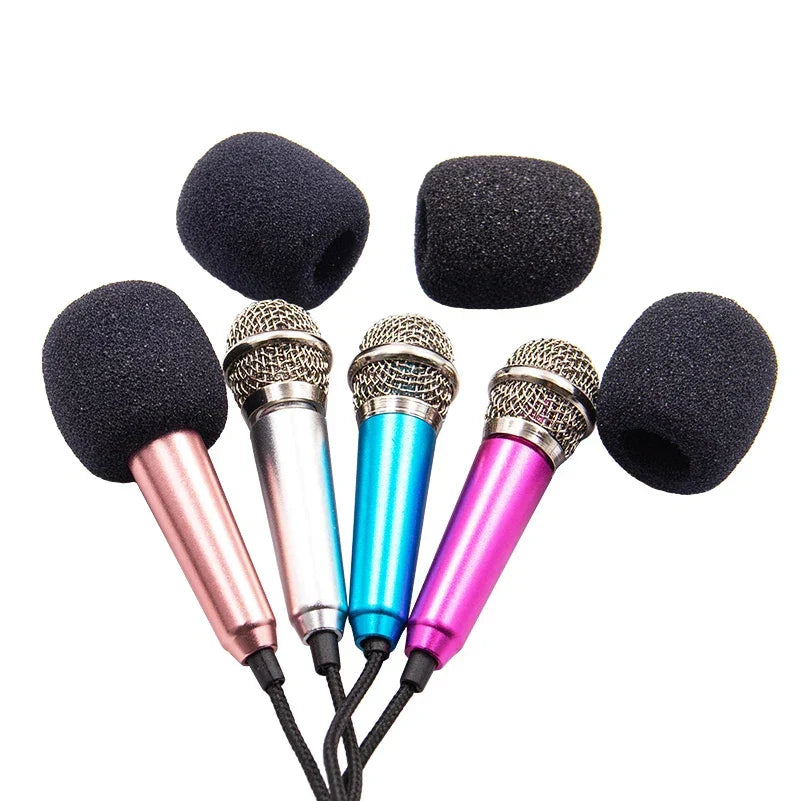 Set of four colorful handheld audio microphones with black foam covers and metallic mesh for karaoke and stereo studio use