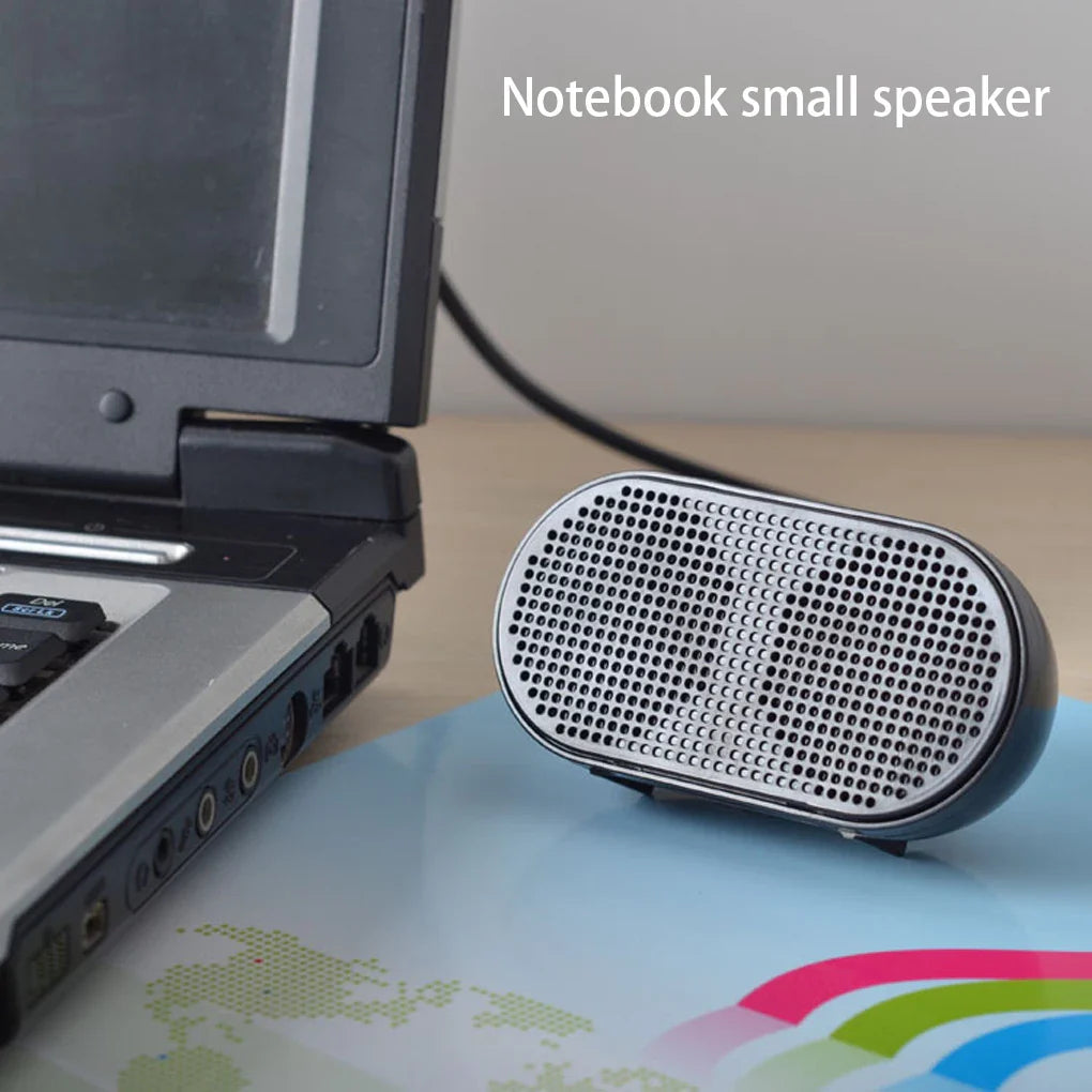 Silver oval-shaped mini speaker with perforated grille and black trim offers good performance for laptop soundbox use