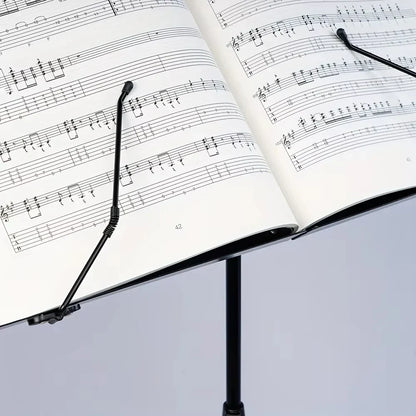 Black folding metal music stand holding open sheet music portable lightweight adjustable stable music with carrying bag