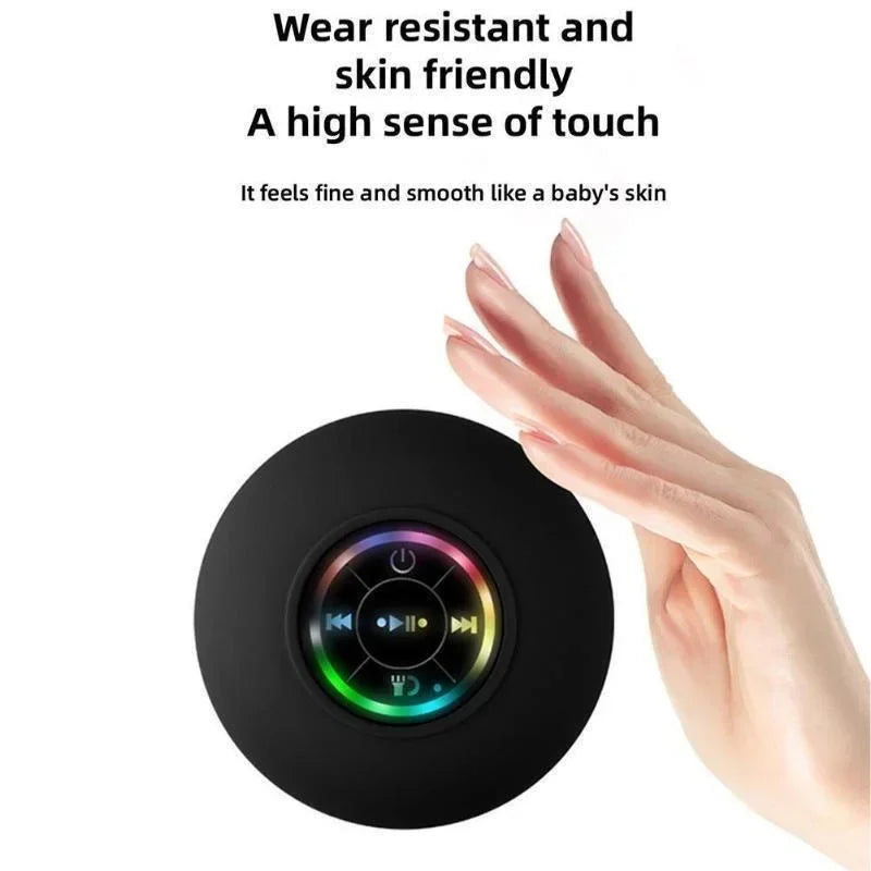 Black circular bluetooth speaker with suction cup, smooth skin-friendly surface, and colorful led ring control buttons