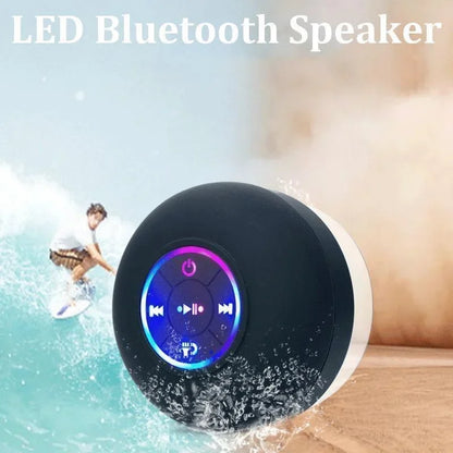 Black and white circular led bluetooth speaker with colorful illuminated control panel and suction cup for portability