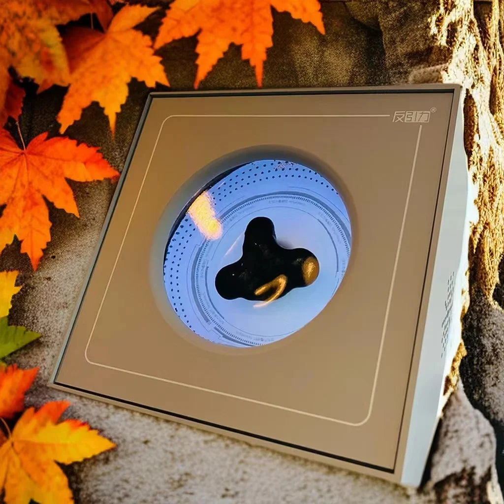 A sleek square metallic portable visual music pickup device with a circular window revealing venom sensor ferrofluid magnetic liquid